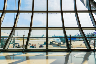 Airport terminal glass window with view of airplane