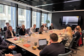  A group of people seated at a table, sharing ideas and interacting with one another.