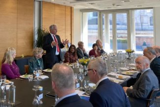 Several individuals gathered at a long table, participating in a discussion.