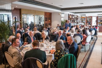 A large group of guests in a bustling dining room for BusinessLDN's London Lunch, engaged in animated conversation and enjoying their meals.