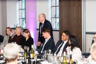 Deputy Mayor for Planning and Regeneration Jules Pipe gives remarks. Several individuals sat next to him, seated around a dining table.