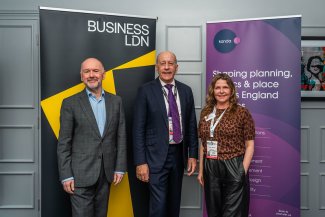 Three individuals stand beside a banner that reads “Business London” at the London Social for UKREiiF: John Dickie, Chief Executive of BusinessLDN; Jules Pipe CBE, Deputy Mayor for Planning and Regeneration; and Karen Alcock, Managing Director and Founder, Kanda.