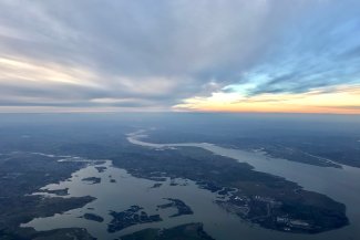 Aerial perspective of a river and lake, highlighting their confluence and surrounding terrain.