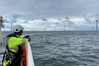 Photo of a construction working looking at a windfarm