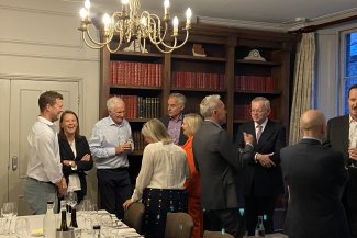 A team of people surrounding a table, sharing ideas and interacting in a collaborative setting.