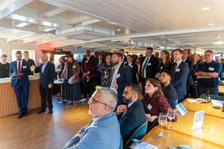  A group of professionally dressed individuals in suits and ties standing together in a well-lit room at the London Reception at Labour Party Conference September 2026.