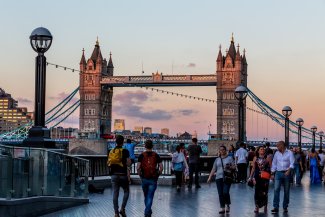 People walking by London Bridge at dusk