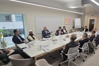 Several individuals gathered at a table in a meeting room, discussing ideas and collaborating.