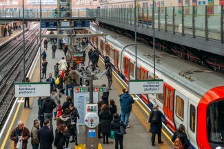 Commuters standing on platform of London Underground Earl's Court Station
