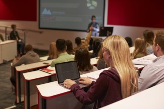 Person in lecture with laptop