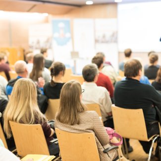 Speaker giving a talk in conference hall at business event. Audience at the conference hall.
