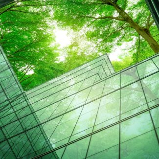 Eco-friendly building in the modern city. Sustainable glass office building with tree for reducing heat and carbon dioxide