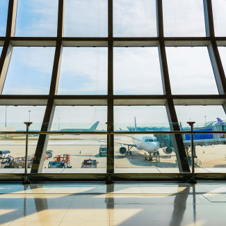 Airport terminal glass window with view of airplane