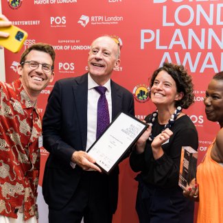 Group taking selfie with award