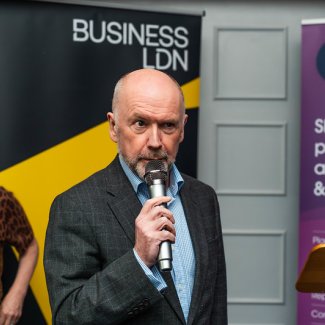 John Dickie delivers a speech at the BusinessLDN London Social at UKREiiF, engaging the audience with his presentation